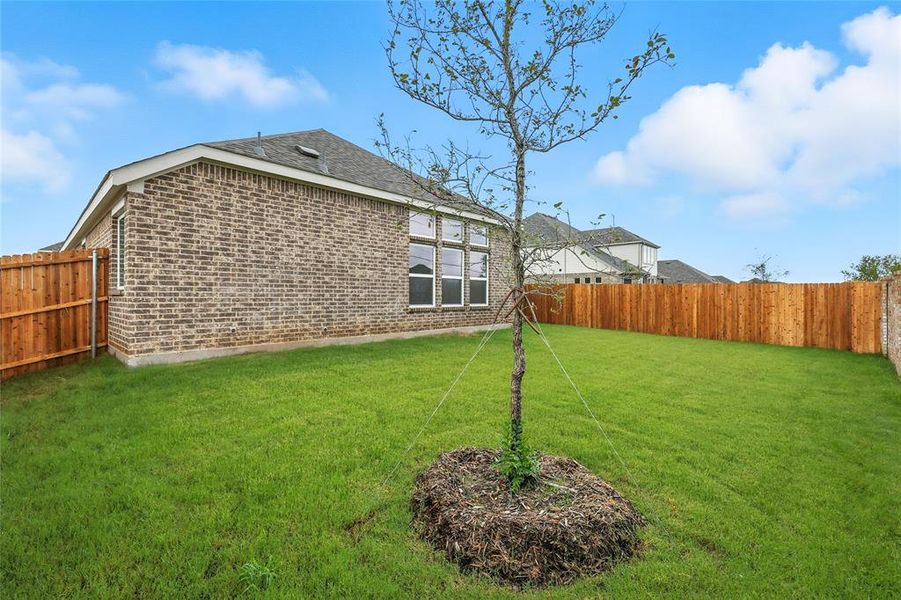 Back of house with a fenced backyard, brick siding, and roof with shingles Back of house with a fenced backyard, brick siding, and roof with shingles