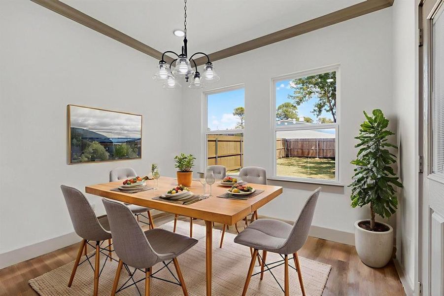 Dining room featuring wood finished floors, crown molding, and a chandelier