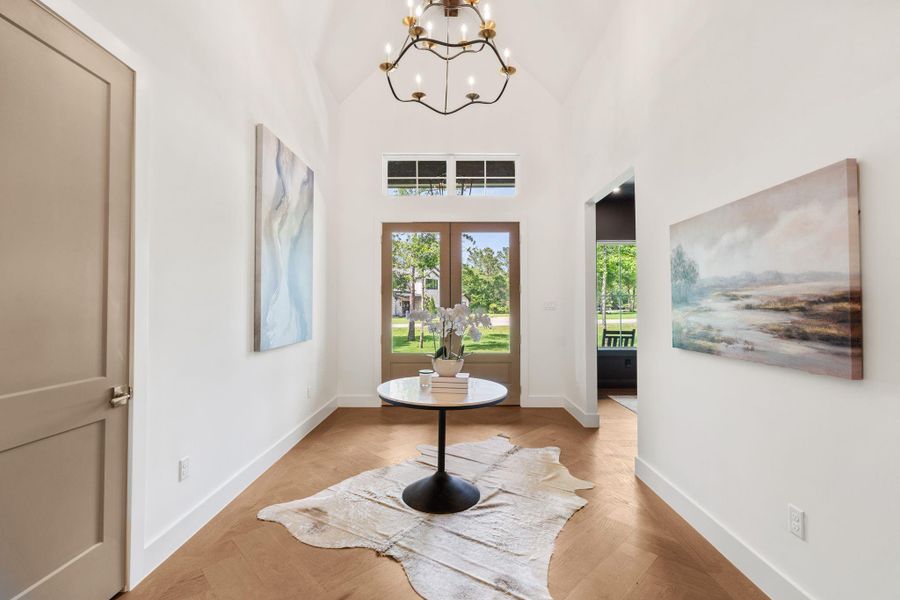 Clean architectural lines frame the view through to the back of the home, showcasing the open layout and natural light beyond. A grand first impression with a clear sightline that highlights the home’s depth and design.