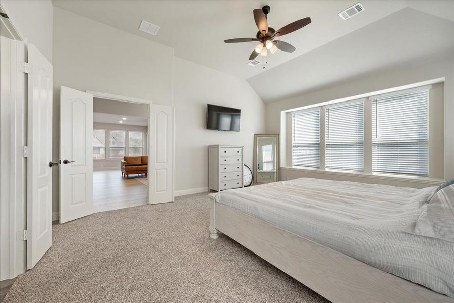 French doors lead into the downstairs primary bedroom and en-suite bath. Carpeted flooring. Lofted ceiling and ceiling fan with light kit.