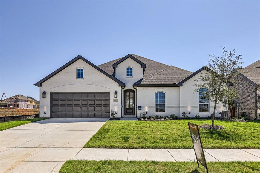 French country inspired facade featuring a front yard