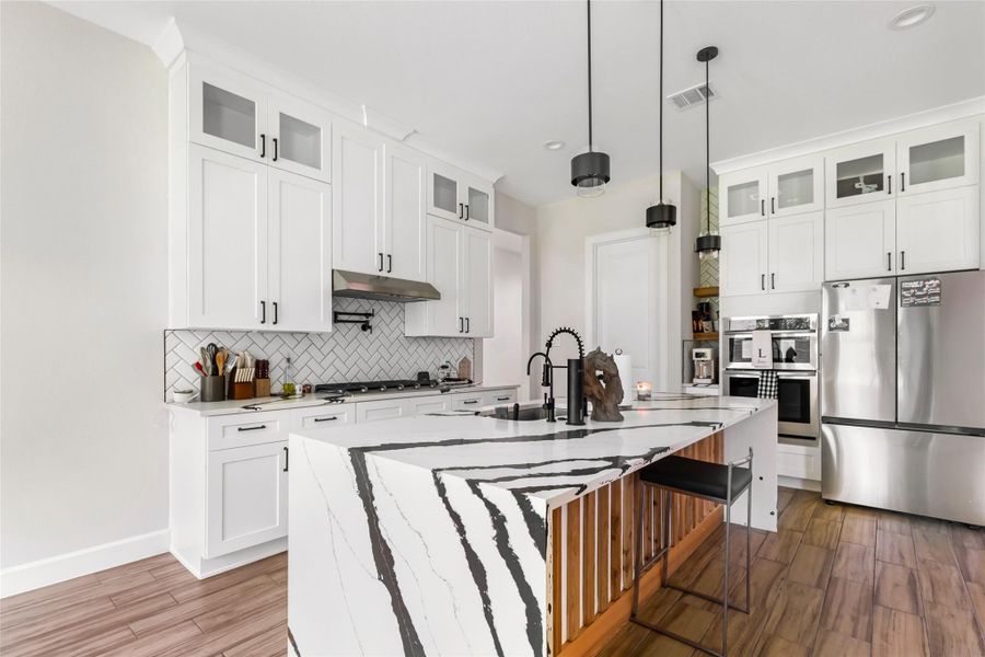 Chefs Kitchen with Quartz Counters, Shaker Cabinets, and Stainless Steel Appliances