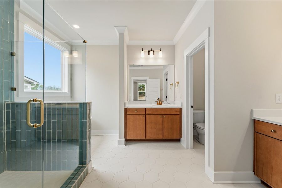 This spacious bathroom offers a glass-enclosed sho