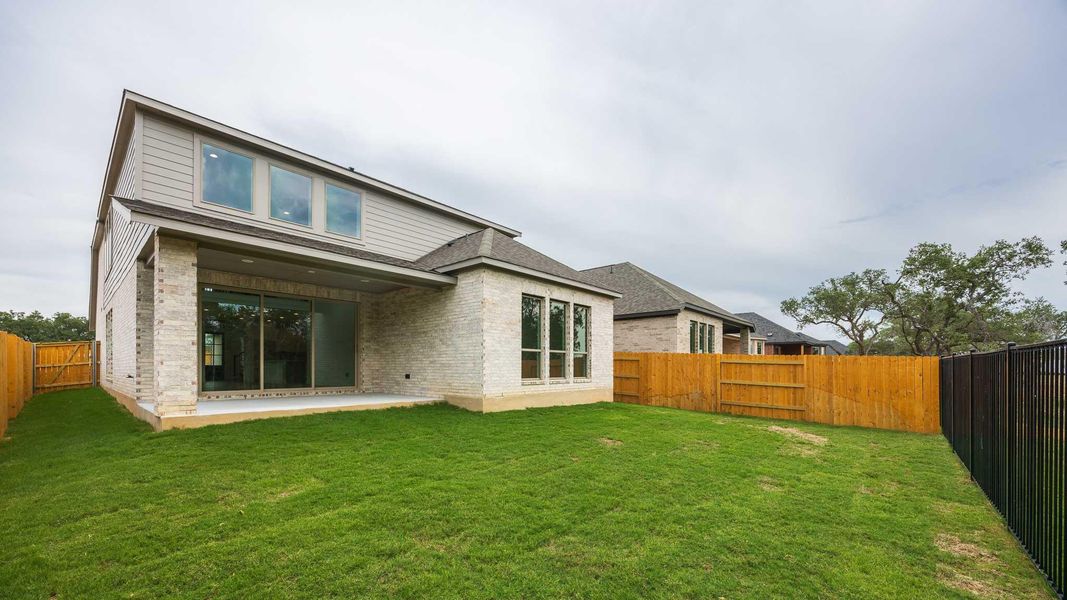 Back of house featuring a fenced backyard, a patio area, and brick siding Back of house featuring a fenced backyard, a patio area, and brick siding
