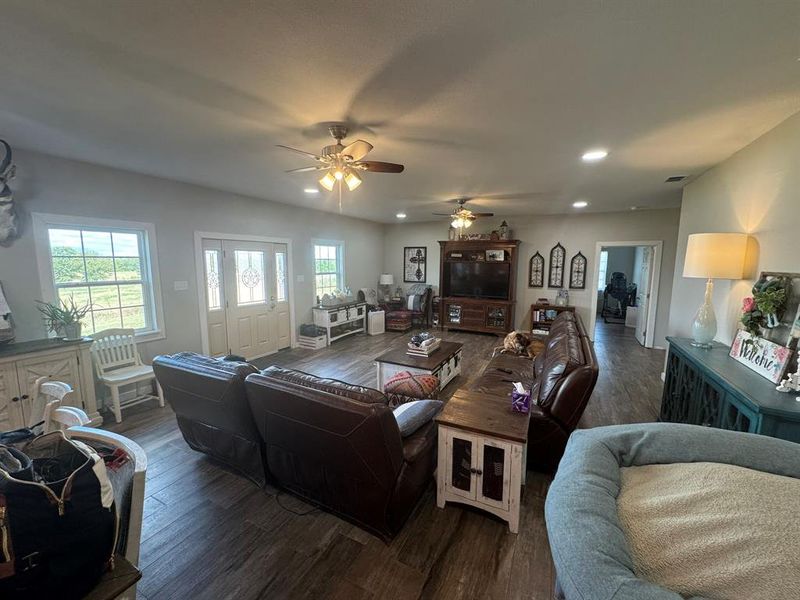 Living area featuring wood finished floors, recessed lighting, and ceiling fan Living area featuring wood finished floors, recessed lighting, and ceiling fan
