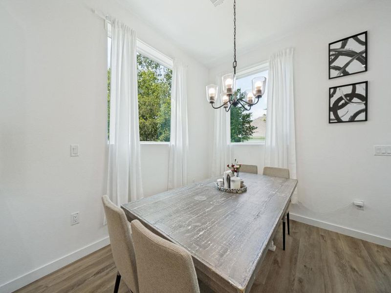Durable plank flooring and a classic chandelier illuminate this inviting dining space. Durable plank flooring and a classic chandelier illuminate this inviting dining space.