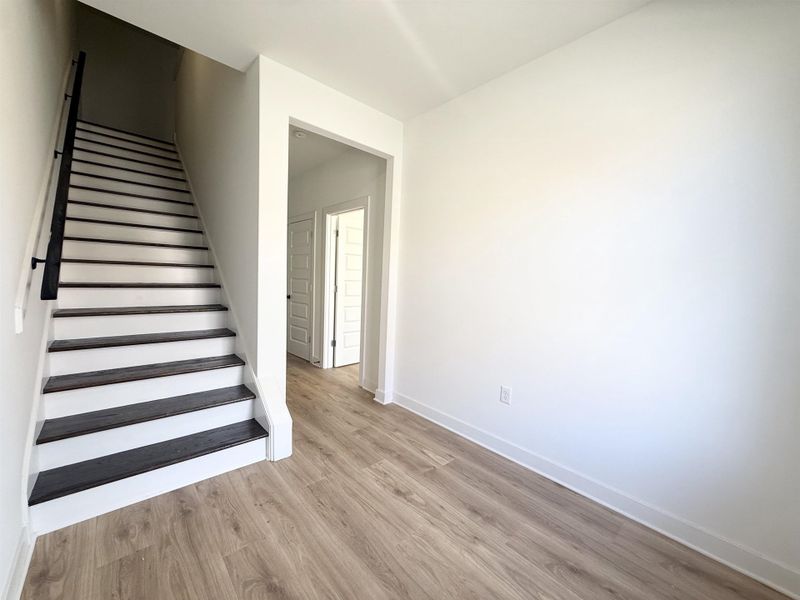 Staircase with wood finished floors and baseboards