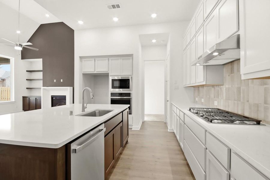 Functional kitchen layout showcasing a built-in gas cooktop and dishwasher, with direct access to the laundry room for added everyday convenience.