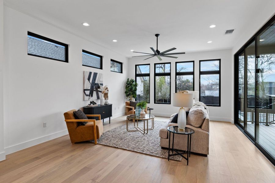 Living room featuring light wood finished floors, healthy amount of natural light, a ceiling fan, recessed lighting, and baseboards