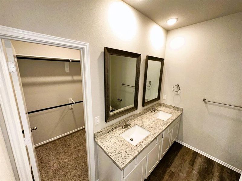 Double sinks, granite counters, framed mirrors- this master bath has it all!