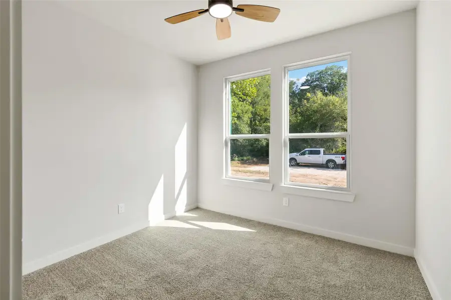 Empty room featuring carpet flooring and ceiling fan Empty room featuring carpet flooring and ceiling fan