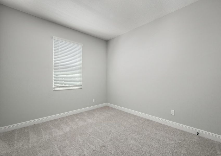 Bedroom with carpet flooring and faux wood blinds on the window Bedroom with carpet flooring and faux wood blinds on the window