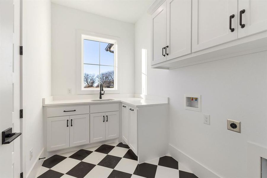 Gosh what a gorgeous laundry room - with a sink under a window, with all the storage, and with those stylish floors!