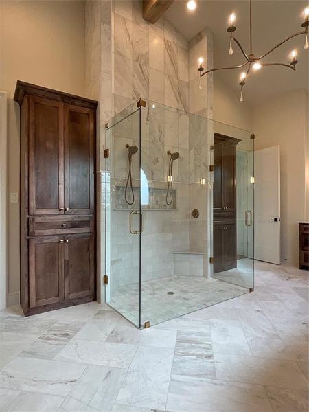 Bathroom with beam ceiling, a high ceiling, a shower with door, and vanity