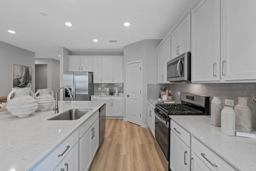 Coronado Model Home Kitchen with White Cabinets and Stainless Steel Appliances at Reserve East in Flagler Beach Coronado Model Home Kitchen with White Cabinets and Stainless Steel Appliances at Reserve East in Flagler Beach