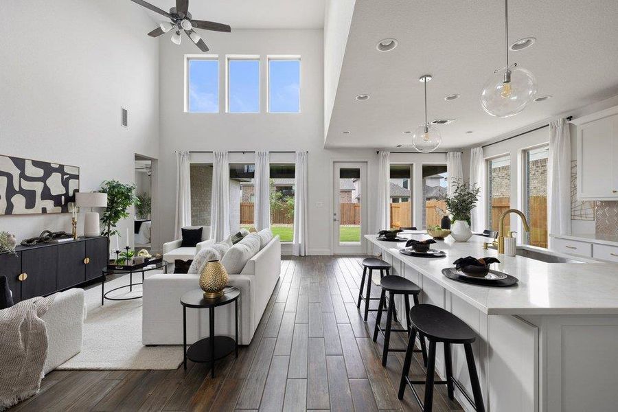 A spacious, airy living area seamlessly connects to a gourmet kitchen, featuring high ceilings and elegant flooring.