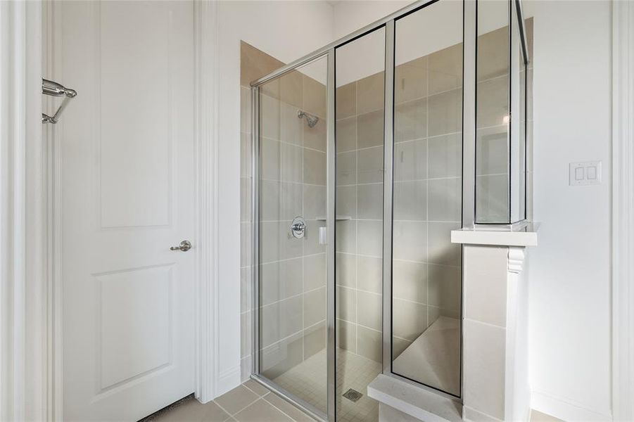 Bathroom featuring a stall shower and light tile patterned flooring
