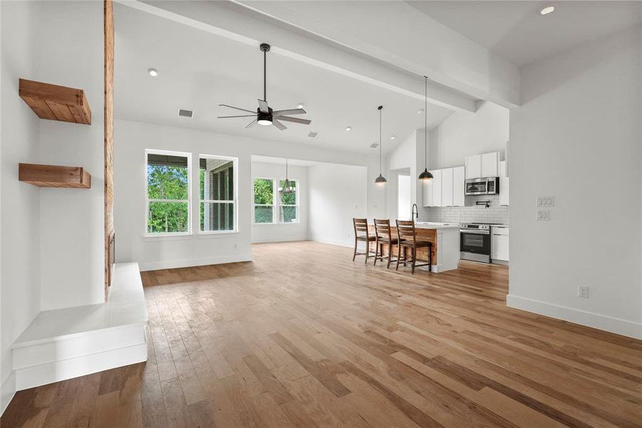 Living area with ceiling fan, light wood-style floors, beamed ceiling, high vaulted ceiling, and recessed lighting