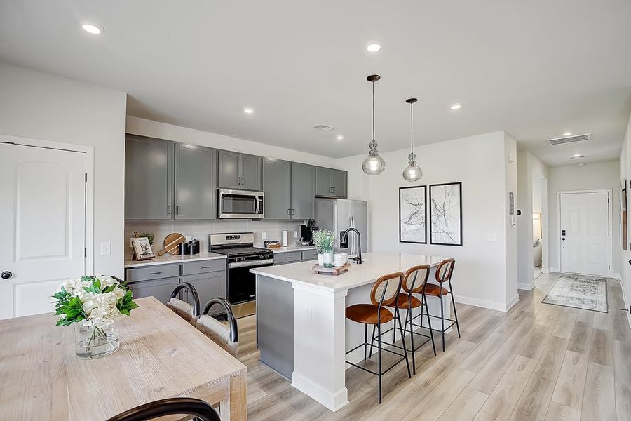 A kitchen with a dining table and white cabinets.