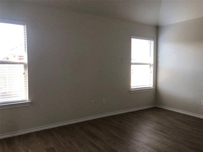 Unfurnished room with lofted ceiling, a healthy amount of sunlight, and dark hardwood / wood-style floors