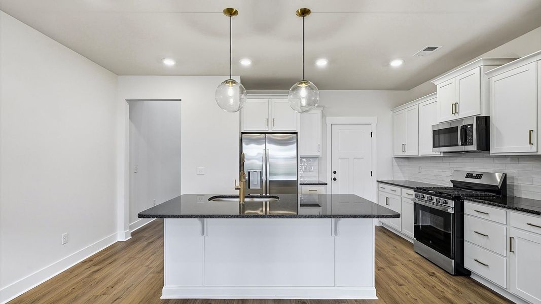 Memorable meals begin in this vibrant kitchen with pendant lighting and a thoughtfully designed island by DRB Homes