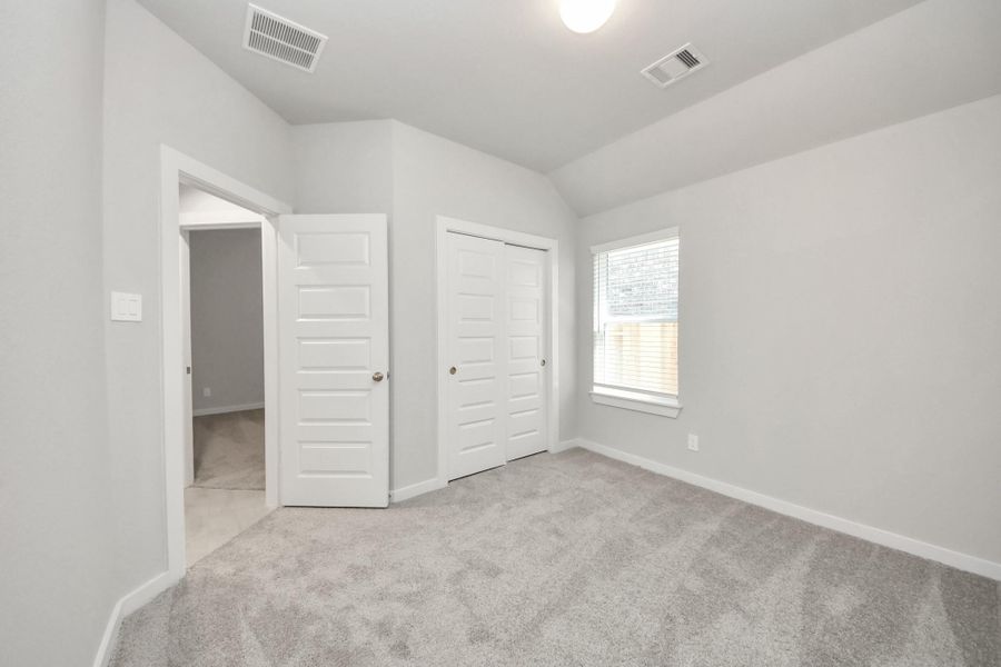 Generously sized secondary bedrooms featuring spacious closets, soft and inviting carpeting underfoot, large windows allowing plenty of natural light, and the added touch of privacy blinds for your personal retreat. Sample photo of completed home with similar floor plan. Actual colors and selections may vary.