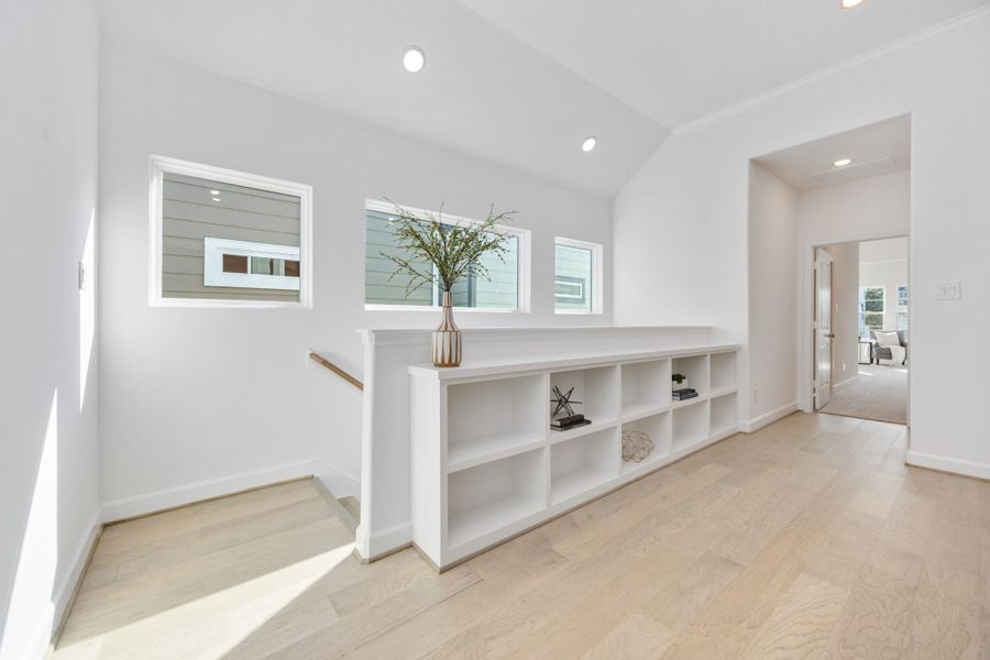 Sunlight streams through clerestory windows, casting the perfect glow on this stylish hallway landing. Bonus: built-in shelving that begs for your favorite reads and travel finds.