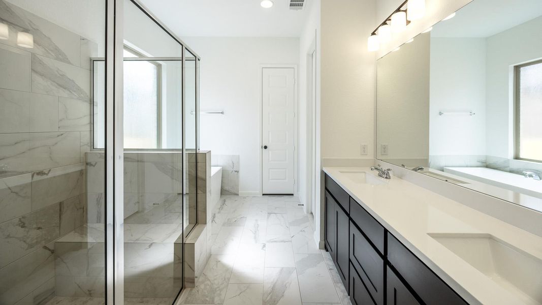 Bathroom featuring a marble finish shower, a freestanding tub, double vanity, and light marble finish flooring Bathroom featuring a marble finish shower, a freestanding tub, double vanity, and light marble finish flooring