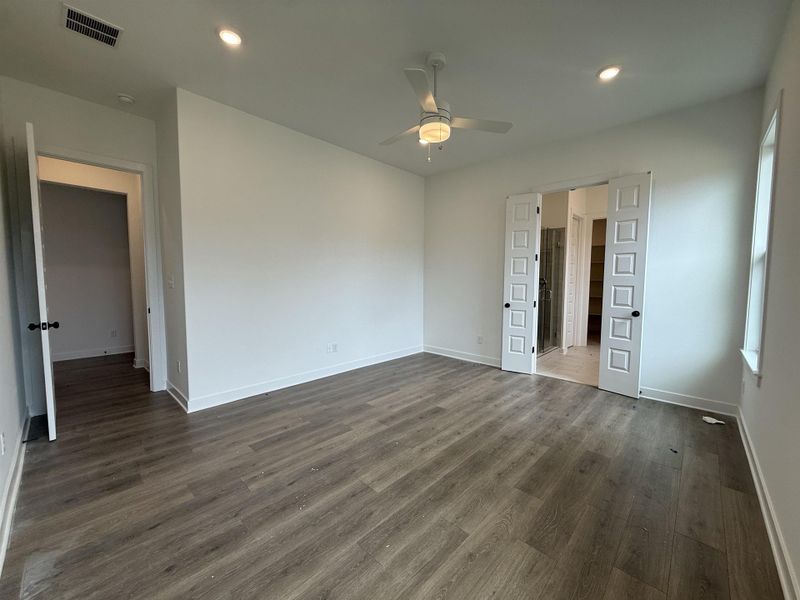 Spacious room featuring wood-finish flooring, recessed lighting, a ceiling fan with light fixture, and white trim
