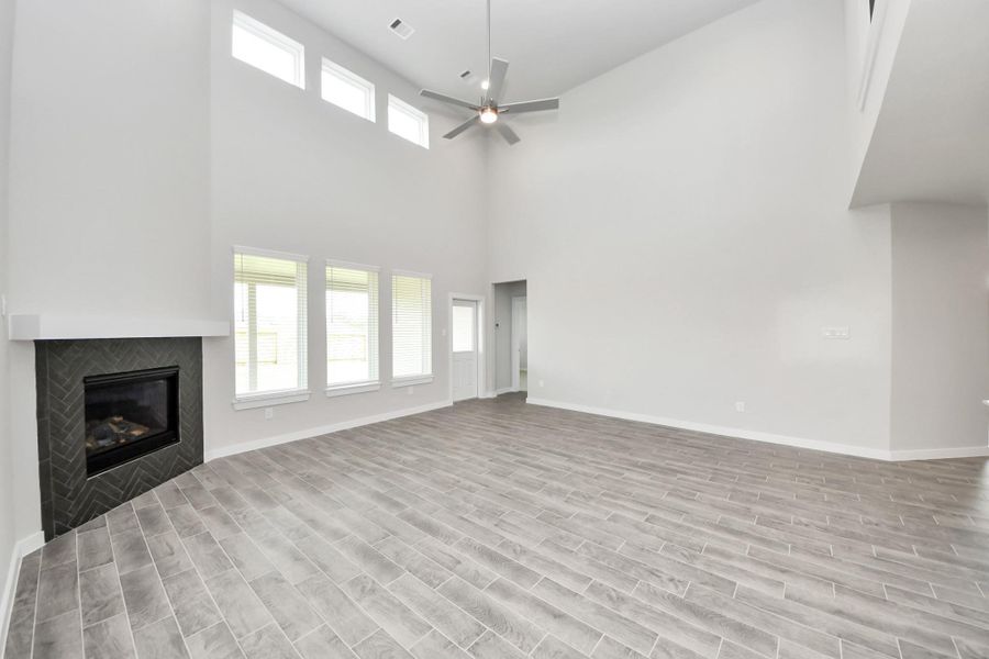 Family room flooded with natural light through the expansive windows. The premium tile flooring adds a touch of luxury to the space, creating the perfect setting for relaxing moments and cherished gatherings with loved ones. Sample photo of completed home with similar floor plan. Actual colors and selections may vary. Family room flooded with natural light through the expansive windows. The premium tile flooring adds a touch of luxury to the space, creating the perfect setting for relaxing moments and cherished gatherings with loved ones. Sample photo of completed home with similar floor plan. Actual colors and selections may vary.