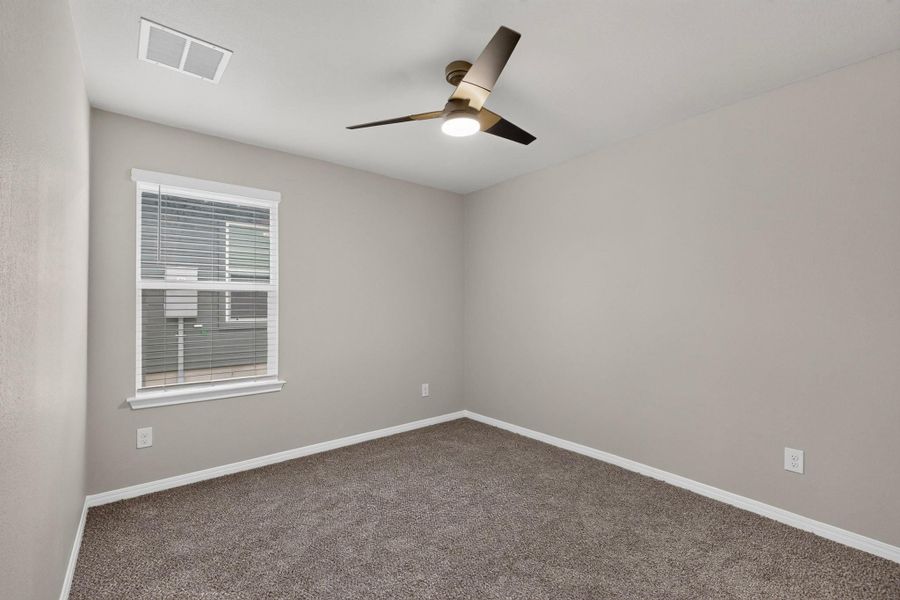 Clean lines and plush neutral carpeting define this versatile secondary bedroom space.