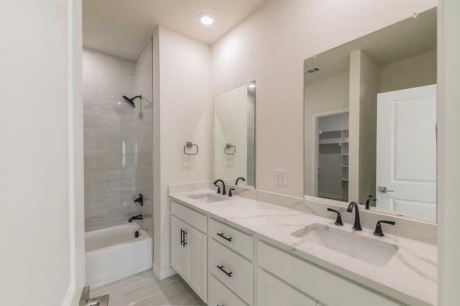 Bathroom with hardwood / wood-style floors, vanity, and tiled shower / bath