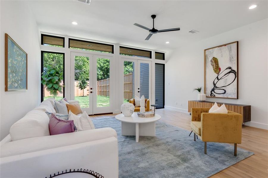 Living room with french doors, light wood-type flooring, and ceiling fan