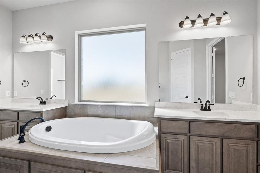 Bathroom with two vanities and a bath