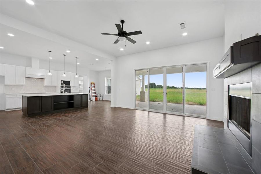Unfurnished living room with recessed lighting, dark wood finished floors, ceiling fan, and a tile fireplace