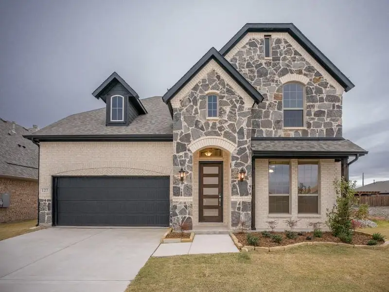 View of front of house featuring a garage and a front yard