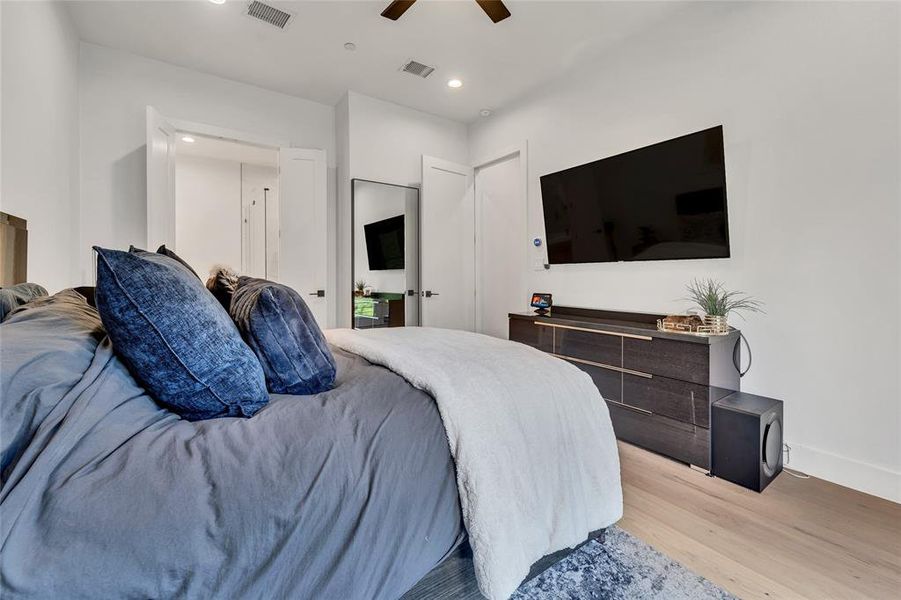 Bedroom with light wood finished floors, recessed lighting, and a ceiling fan Bedroom with light wood finished floors, recessed lighting, and a ceiling fan
