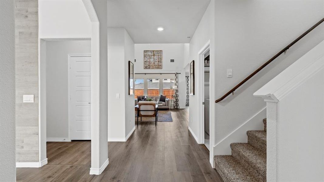 Spacious hallway featuring wood-finish flooring, recessed lighting, and white baseboards Spacious hallway featuring wood-finish flooring, recessed lighting, and white baseboards