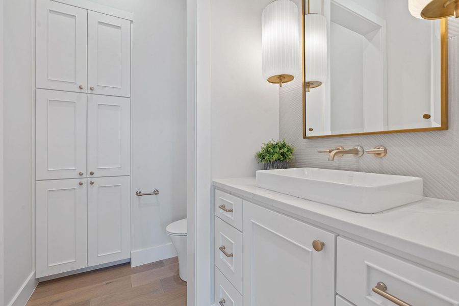 Bathroom featuring toilet, baseboards, wood finished floors, and vanity Bathroom featuring toilet, baseboards, wood finished floors, and vanity