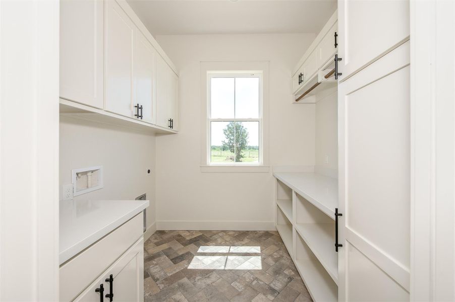 Laundry room with hookup for a washing machine, electric dryer hookup, and cabinet space