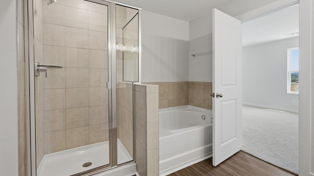 Primary bathroom connected to bedroom with shower and bathtub
