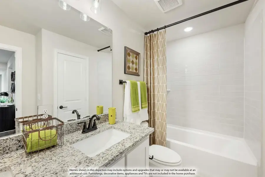 Bathroom with granite countertop vanity, undermount sink, and tub-shower combo with white tile surround
