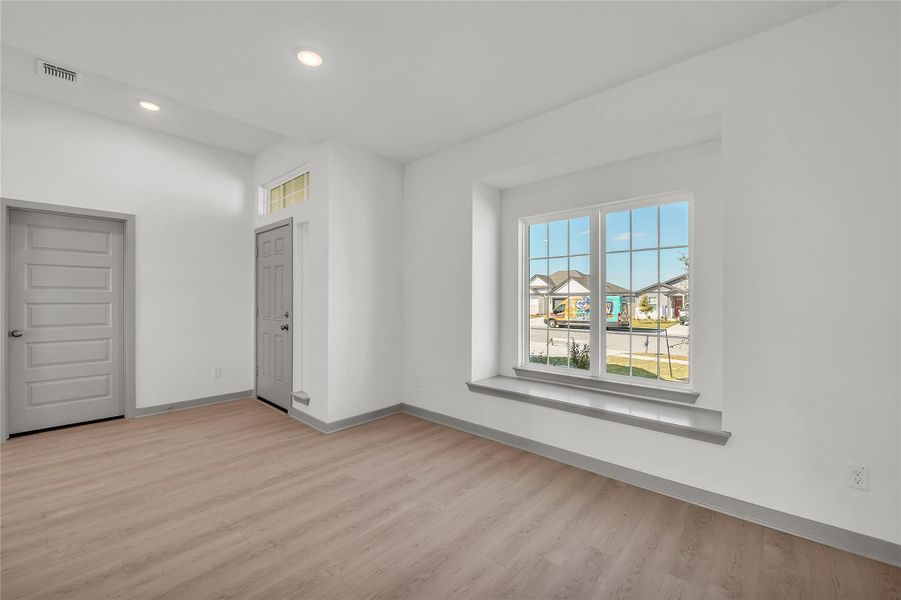 Empty room featuring light wood finished floors and recessed lighting
