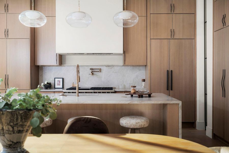Kitchen with modern cabinets, light stone counters, and a breakfast bar area