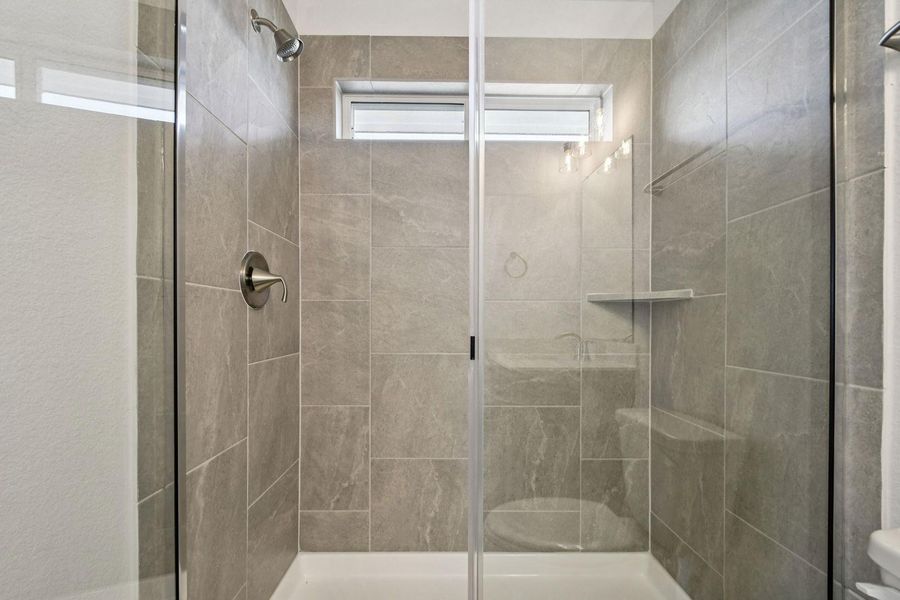 Full bath with a shower stall and toilet