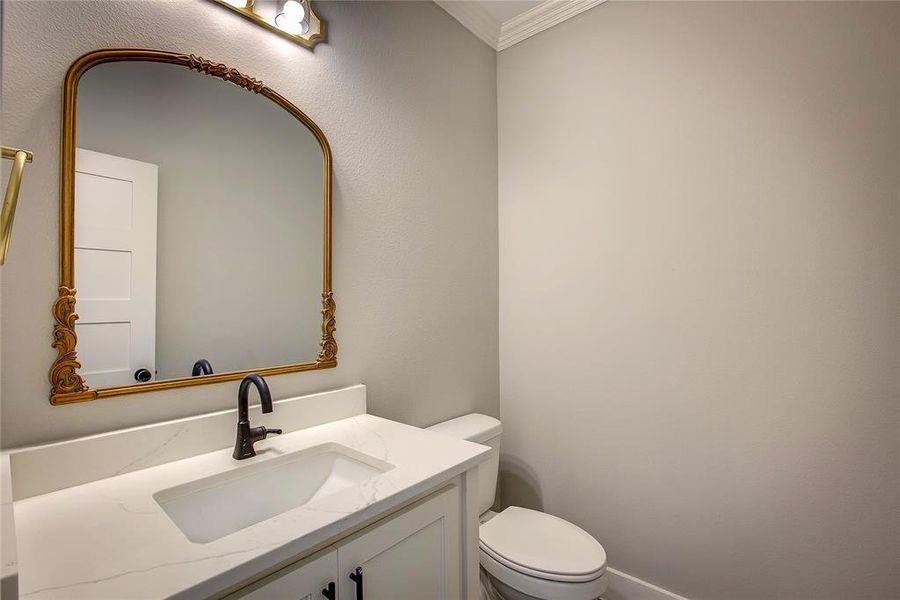 Bathroom with crown molding, toilet, and vanity