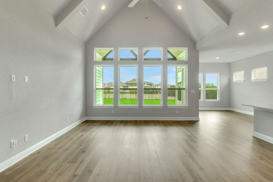 Unfurnished living room featuring ceiling fan, visible vents, wood finished floors, baseboards, and recessed lighting