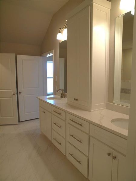 Bathroom with vanity and lofted ceiling