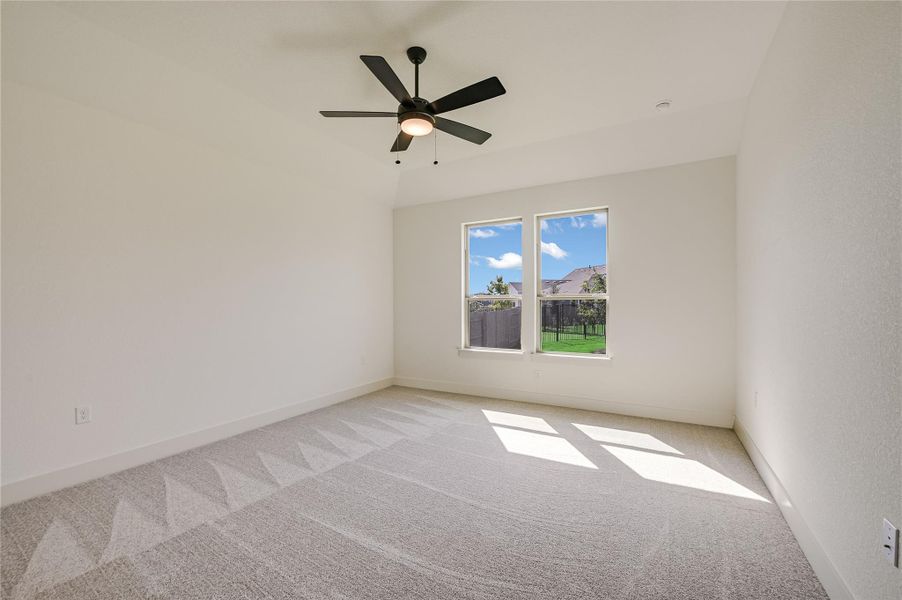 Carpeted empty room with baseboards and a ceiling fan