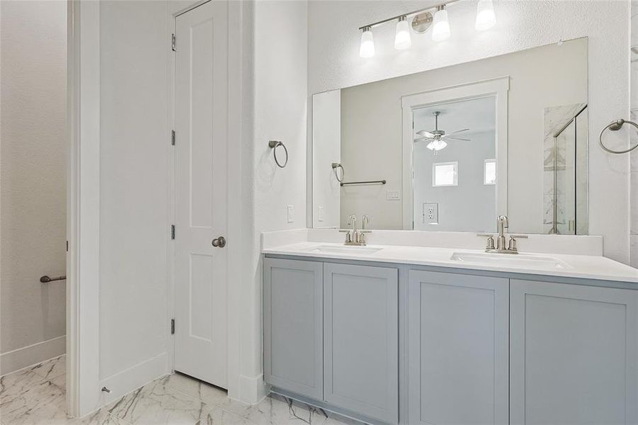 Bathroom with double vanity, ceiling fan, and tile patterned floors